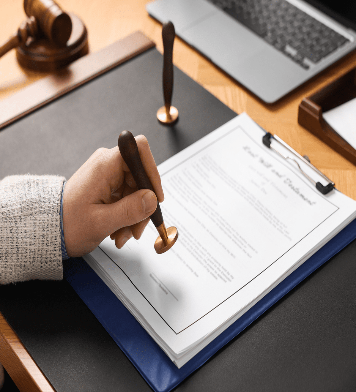 Hand holding seal over legal paper